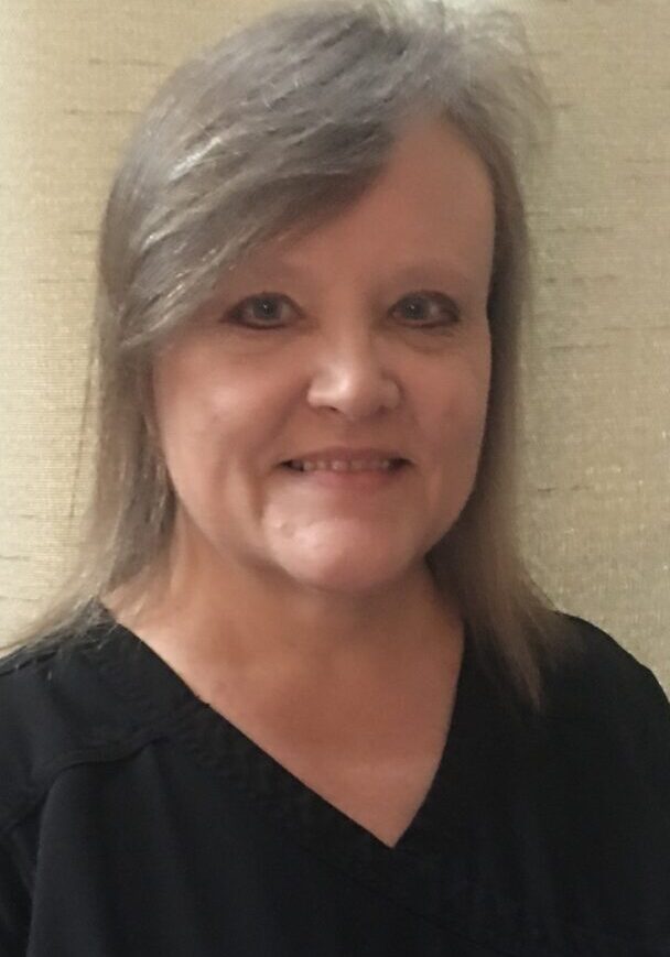 A woman with gray hair wearing black shirt.